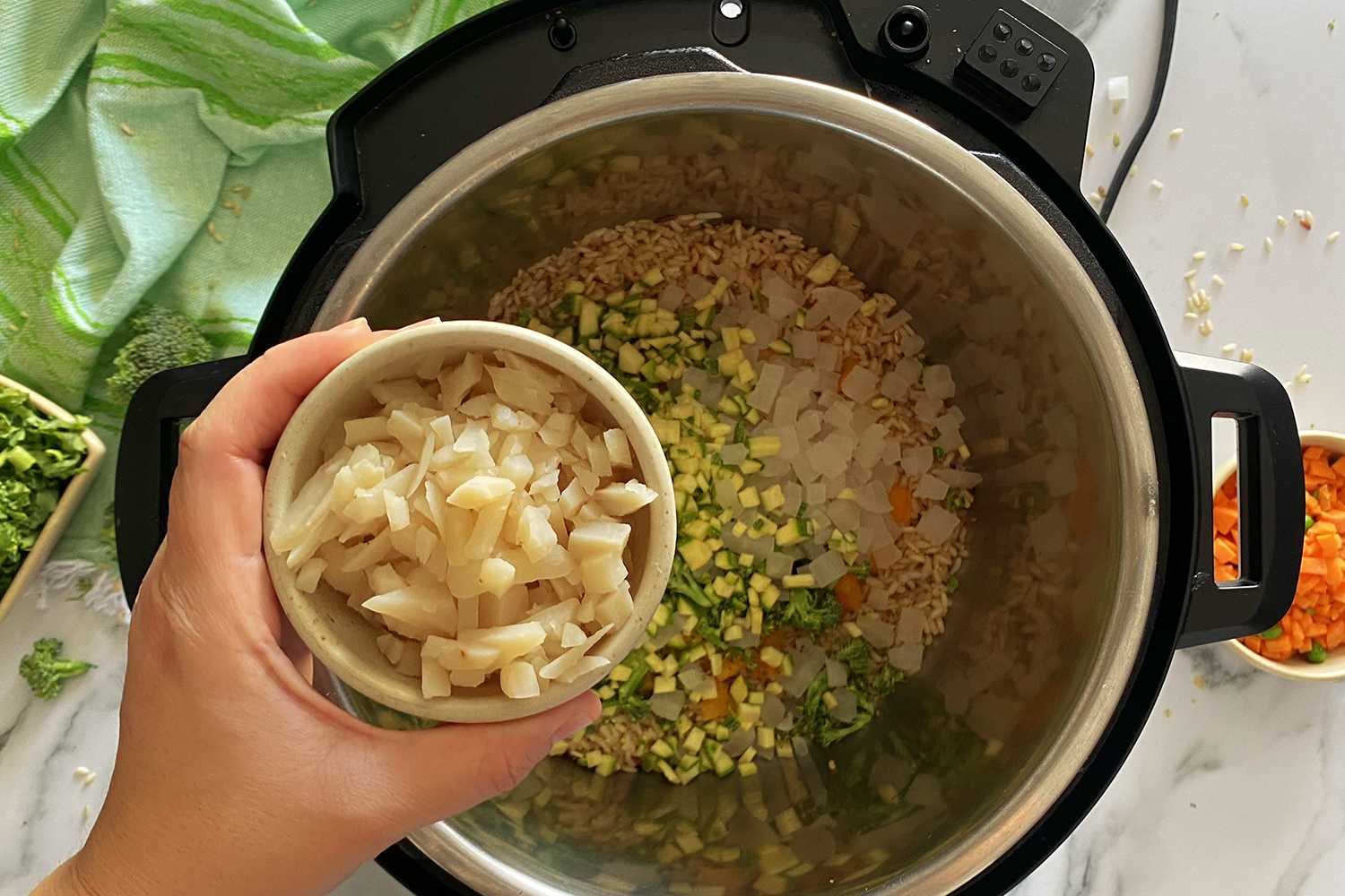 https://www.corriecooks.com/wp-content/uploads/2021/03/Instant-Pot-Brown-Rice-and-Vegetables-adding-water-chestnuts.jpg