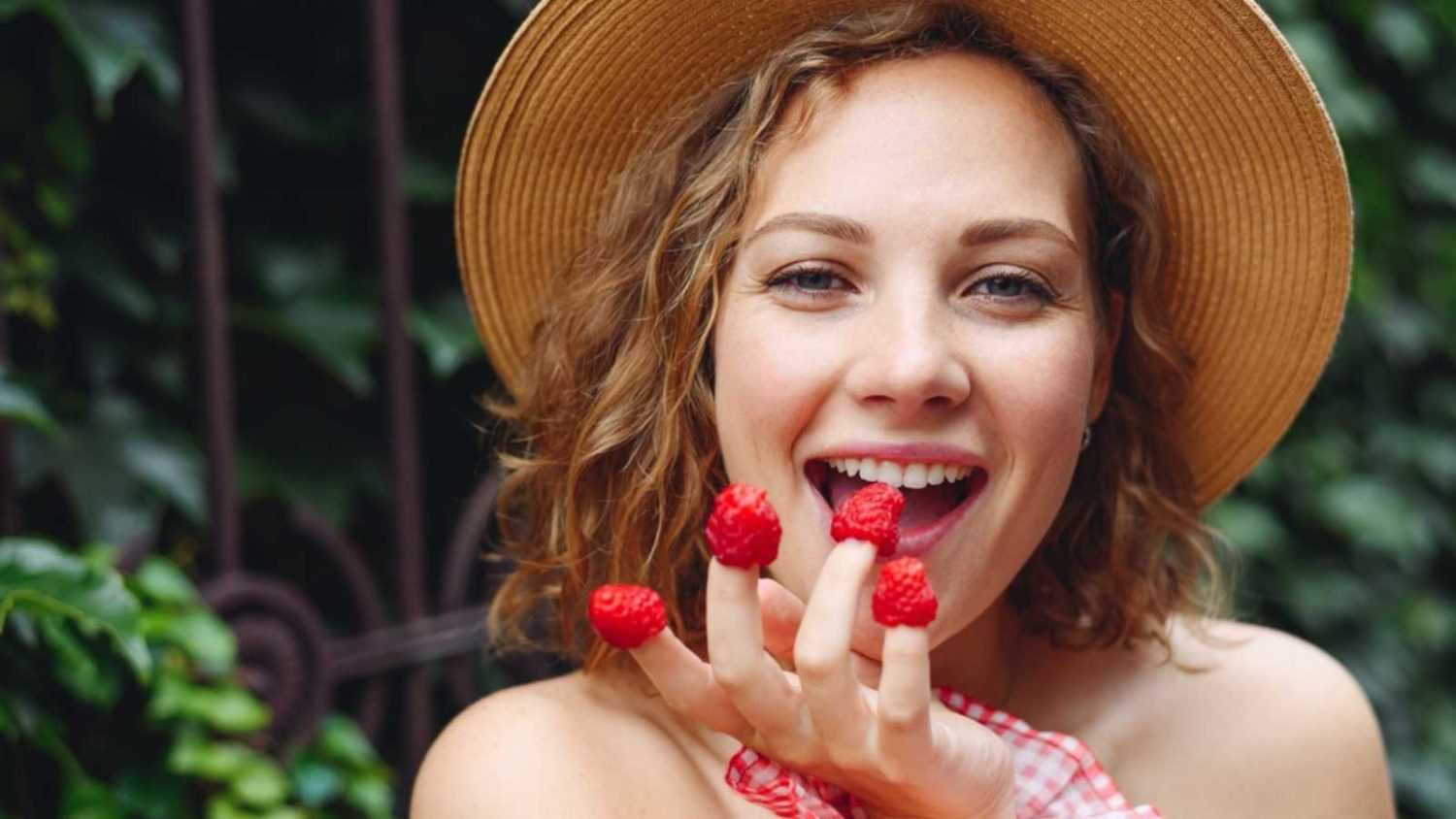 Woman eating raspberry