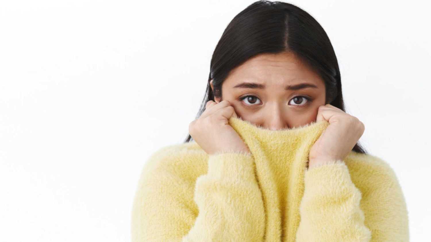 Woman scared closing face with dress