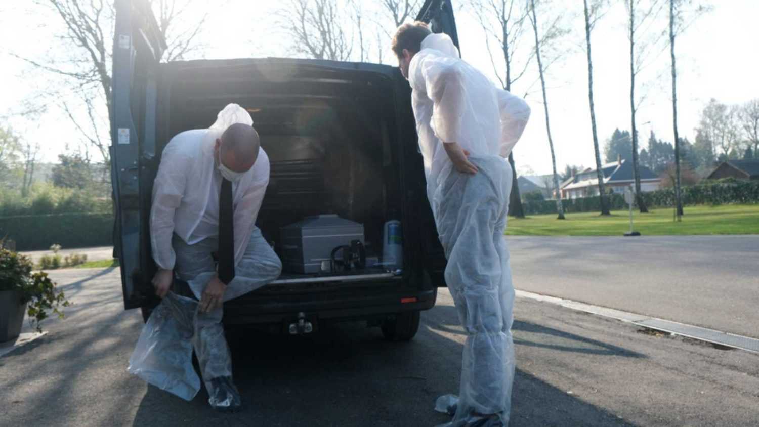 Employees of funeral service company prepare themselves by putting on protective suits and face masks to disinfect the coffin of a COVID-19 victim, in Gilly, Belgium, 03 April 2020.
