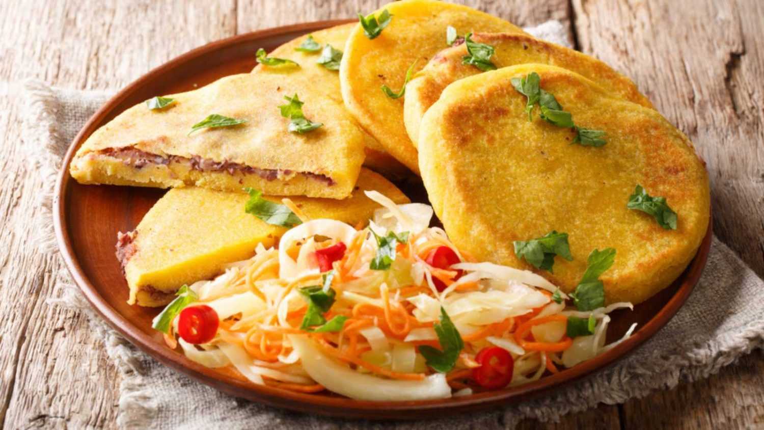 Tasty vegetarian pupusas recipe served with curtido closeup on a plate on the table. horizontal
