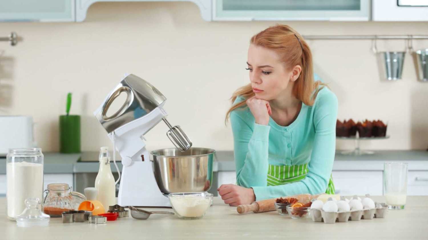 Young woman using a food processor to make a dough