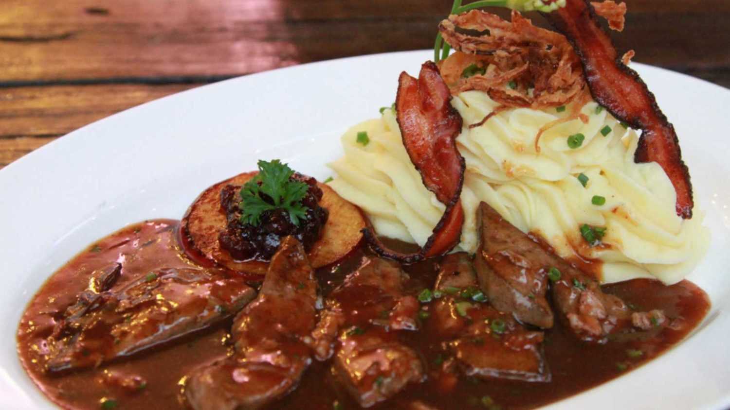 Veal liver Berlin style, served with caramelized apple ring, potato mash and crispy bacon