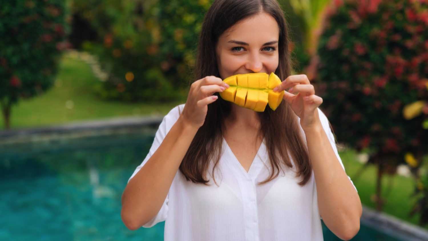 Woman eating mangoes
