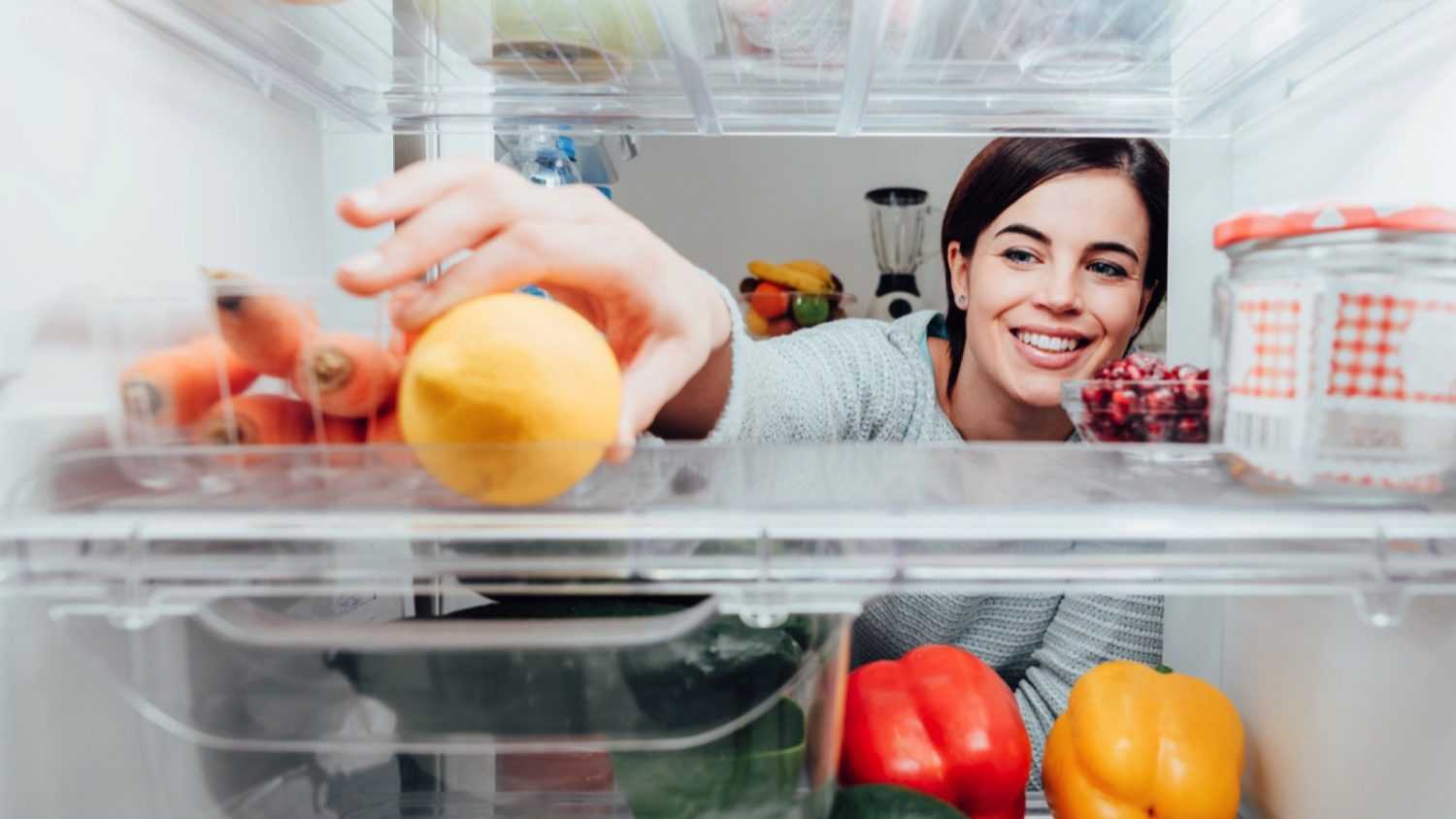 Woman taking items from fridge