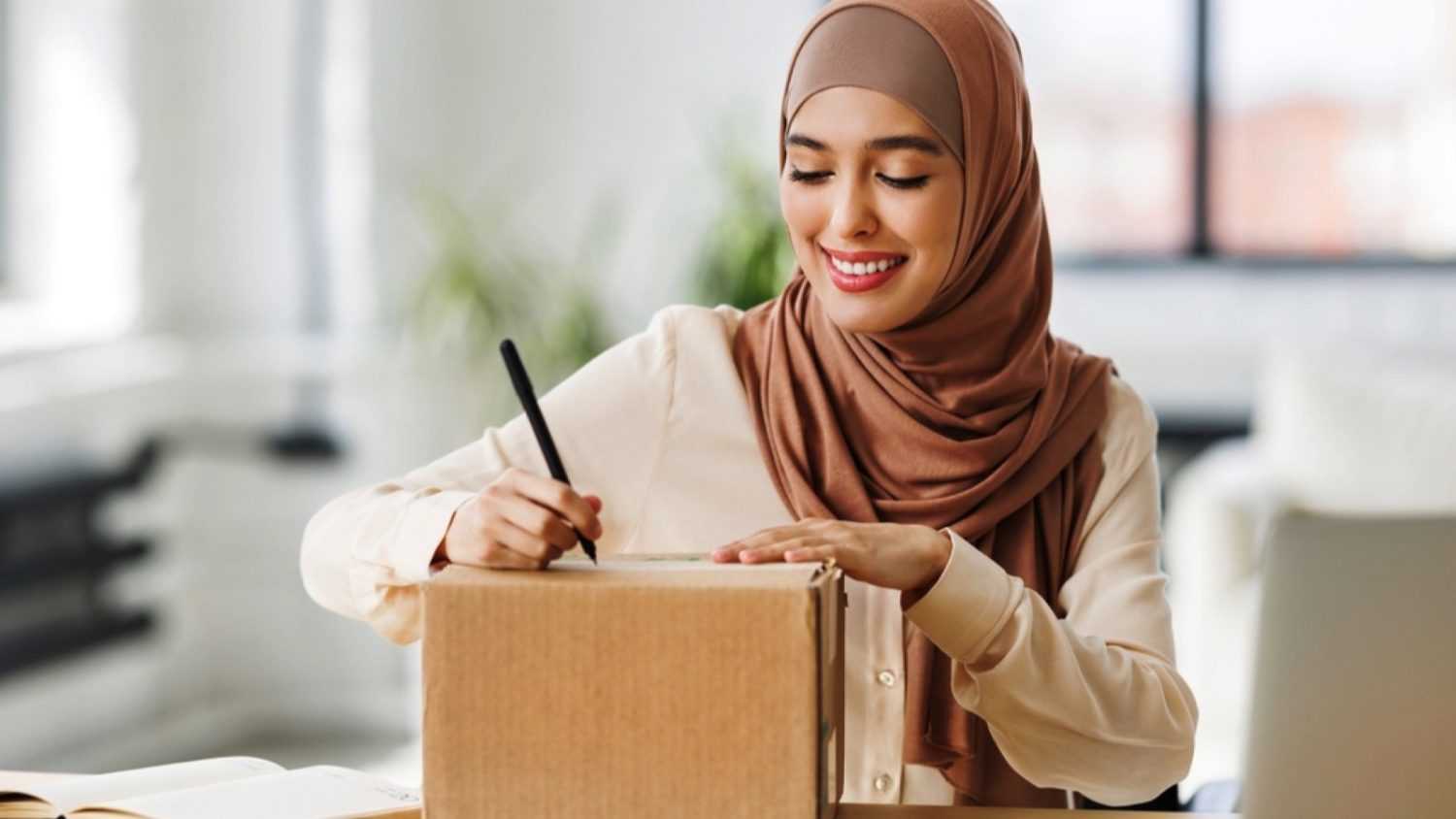 Woman labeling cardboard box