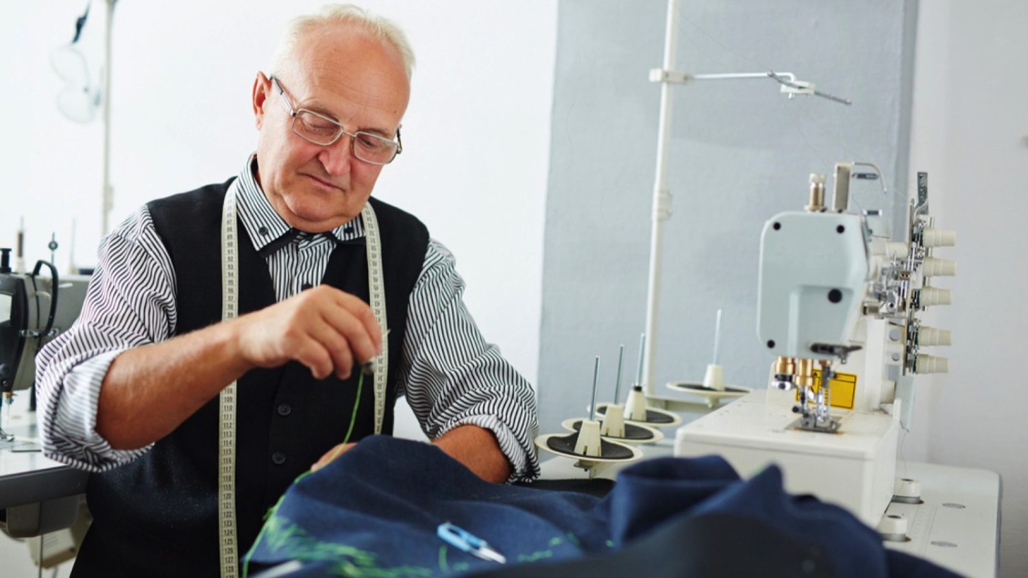 Old man or baby boomer working as tailor